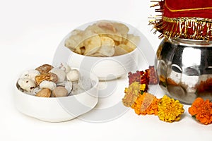 Kalash with coconut and chunni with floral decoration for navratri pooja. Picture of dry fruit and potato chips in the bowl