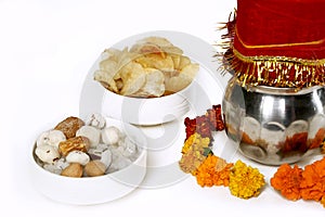 Kalash with coconut and chunni with floral decoration for navratri pooja. Portrait of dry fruit and potato chips in the bowl