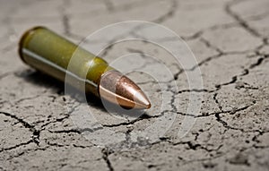 Kalashnikov bullet on desert land background