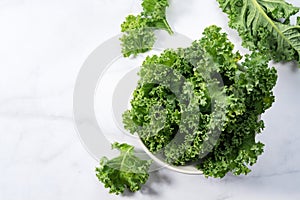 Kale in bowl on marble background. curly kale