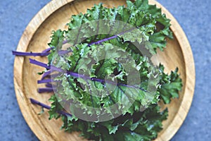 Kale Leaves with Purple Stem and Veins on Wooden Dish Overhead