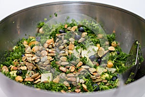 Kale salad in silver salad bowl on white background