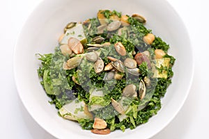 Kale salad in white bowl on white