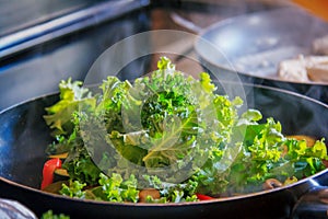 Kale Sauteing in the frying pan with peppers