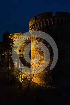 Kalemegdan fortress gate with towers and a wooden bridge at night in Belgrade