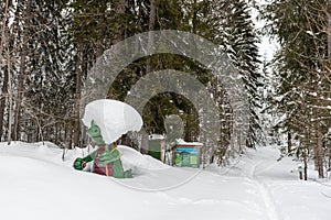 Kali the Ramsaurier, likeable, snow covered, green dinosaur mascot of ski school at ski region Ramsau Dachstein, Steiermark.