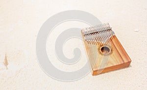 Kalimba made from wooden board with metal, play on hands and plucking the tines with the thumbs