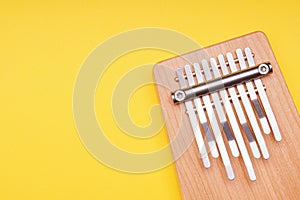 kalimba music instrument on yellow background with copy space