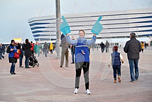 KALININGRAD, RUSSIA. The girl volunteer of the FIFA World Cup 2018 against the background of Baltic Arena stadium