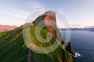 Kallur lighthouse on green hills of Kalsoy island