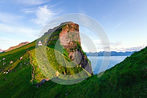 Kallur lighthouse on green hills of Kalsoy island