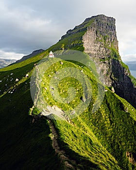 Kallur lighthouse on green hills of Kalsoy island