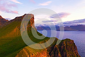 Kallur lighthouse on green hills of Kalsoy island photo