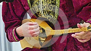 A kalmyk man performs folk music. Stringed musical retro instrument close-up