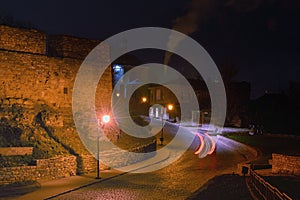 Scenic early winter morning landscape view of old winding cobble stone road between ancient buildings.