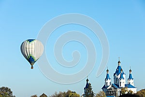 KAMIANETS-PODILSKYI, UKRAINE - OCTOBER 06, 2018: Beautiful view of hot air balloon flying near Saint George`s Cathedral. Space fo