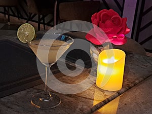 Kamikaze cocktail on a table with candle and rose.