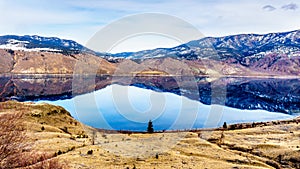 Kamloops Lake with the surrounding mountains reflecting on the quiet surface photo
