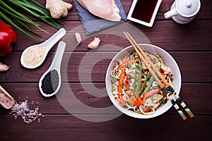 Kamut noodles in Asian style with chicken on dark wood background