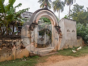 An arched entrance gateway to an old house on the streets of the village of