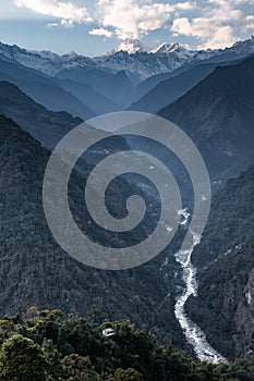 Kangchenjunga mountain with clouds above. Among green hills with concrete fortress and river that view in the evening in Sikkim.