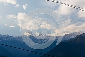 Kangchenjunga mountain with clouds above. Among green hills and trees that view in the evening in North Sikkim, India