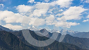 Kangchenjunga mountain with clouds above. Among green hills that view in the evening in North Sikkim, India