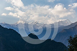 Kangchenjunga mountain with clouds above. Among green hills that view in the evening in North Sikkim, India