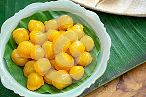 Kanom Thongyip and Thongyhod, egg yoke fudge balls cooked in syrup on banana leaf from topview in the small dish ready to serve