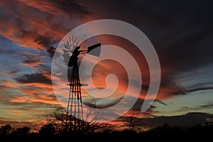 Kansas Awesome Sunset with colorful clouds, and a farm Windmill silhouette .