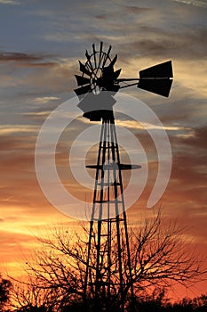 Kansas Awesome Sunset with colorful clouds, and a farm Windmill silhouette .