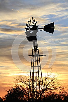 Kansas Awesome Sunset with colorful clouds, and a farm Windmill silhouette .