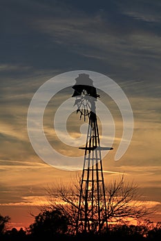 Kansas Awesome Sunset with colorful clouds, and a farm Windmill silhouette .