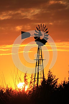 Kansas Blazing orange and yellow sky with a Windmill silhouette