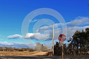 Kansas Country Road with blue sky,clouds, and a stop sign.