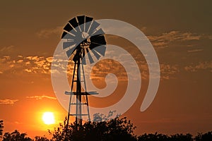 Kansas Sunset with a colorful sky , sun and Windmill silhouette