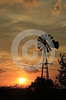 Kansas Sunset Windmill with gray sky and white clouds