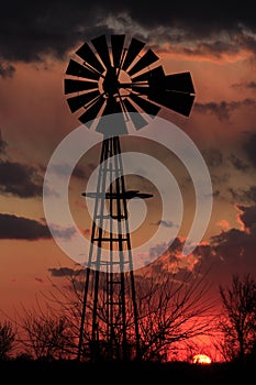 Kansas Windmill sillhouette with storm clouds out in the country.