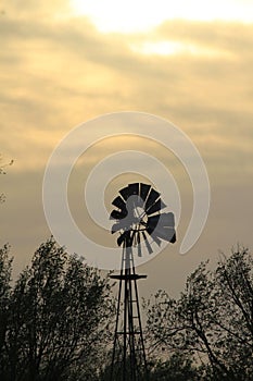 Kansas Windmill Sunset with clouds and Trees