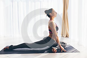 Kapotasana. Beautiful yoga woman practice in a traning hall background. photo