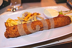 Karadjordjeva schnitzel, Karageorge Schnitzel, serbian breaded cutlet, rolled veal pork steak on a plate with french fries and photo