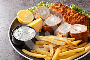 Karadjordjeva steak deep fried rolled veal or pork schnitzel served with fried potatoes with french fries and tartar sauce close-