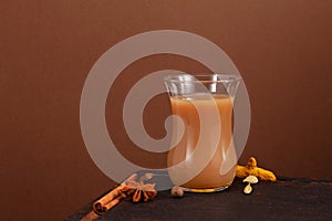 Karak tea or Masala chai on brown background. Selective focus, copy space