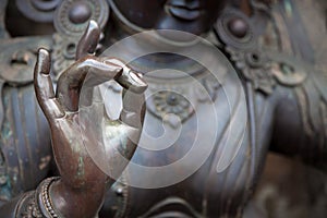 Detail of Buddha statue with Karana mudra hand position photo