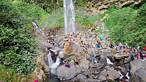 KARANG ANYAR INDONESIA, JULY 14 2019 : high waterfall and beautiful between trees. people are visiting the waterfall