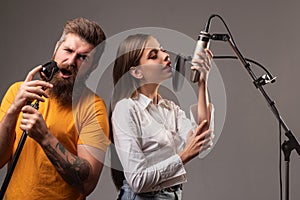 Karaoke singers couple. Woman and man singing with music microphone.