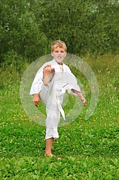 Karate boy kick a leg outdoor