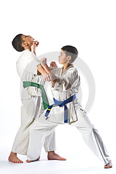 Karate boy in kimono fighting on a white background