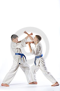 Karate boy in kimono fighting on a white background