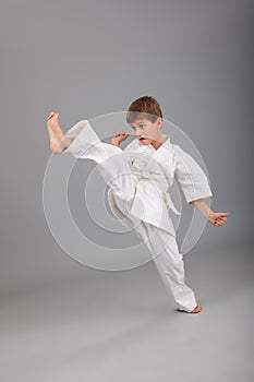 Karate boy in white kimono fighting